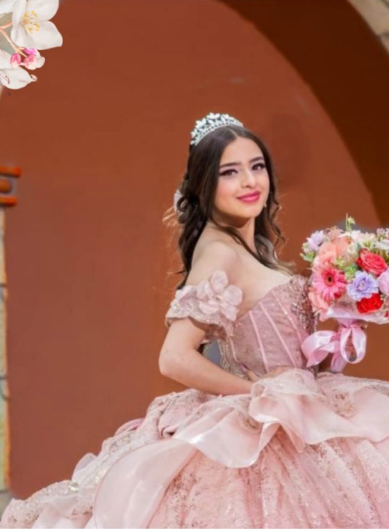 Dayra Julieta bajo un arco de cantera con su ramo